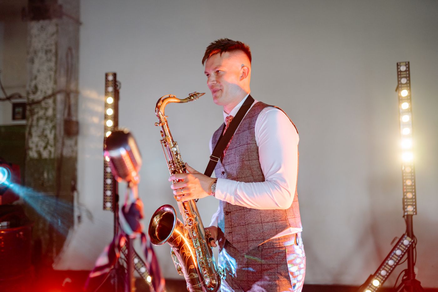 Saxofonist som spiller live under scenelys
